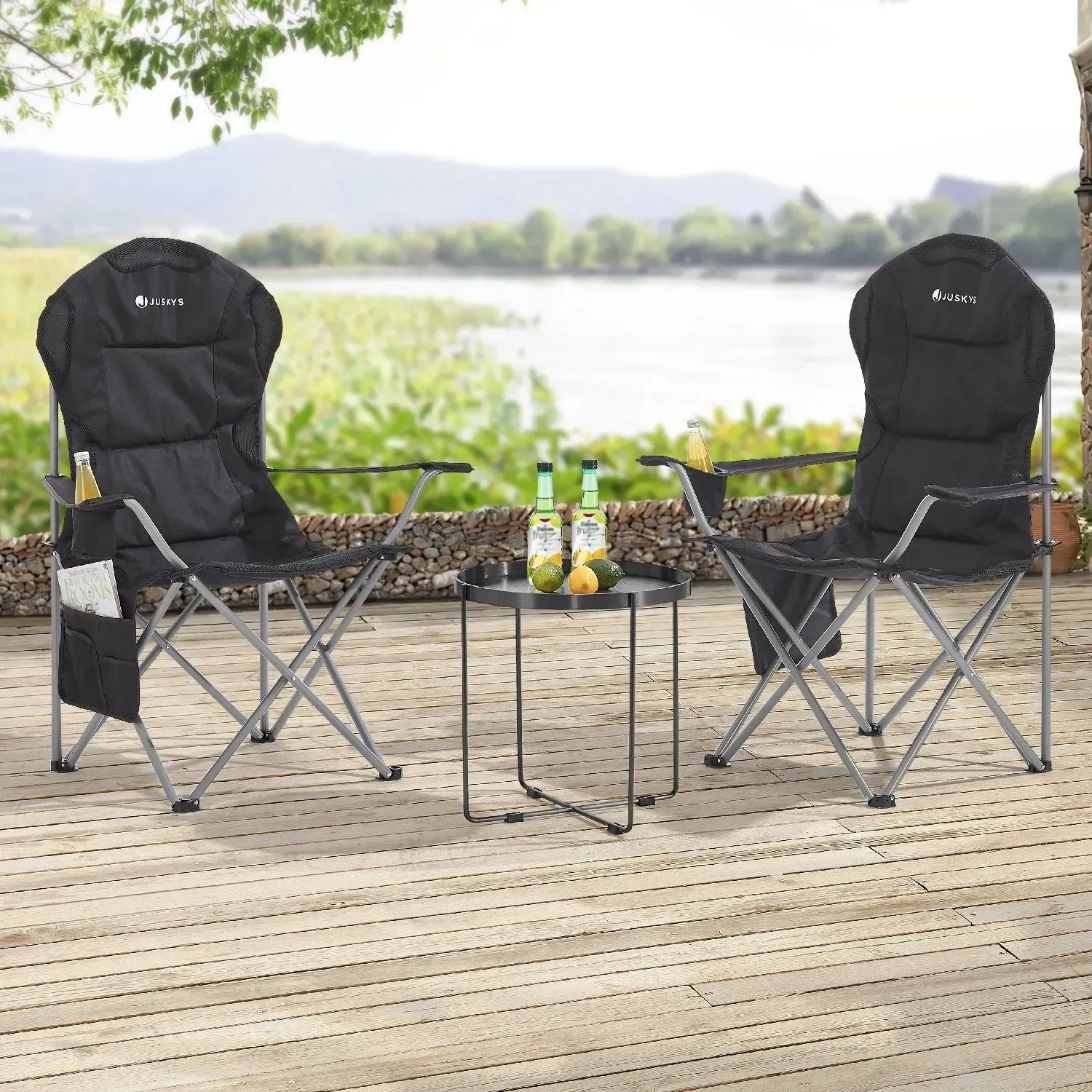 Zwei schwarze Juskys Campingstühle Lido mit Getränkehalter und Tisch auf einer Terrasse.