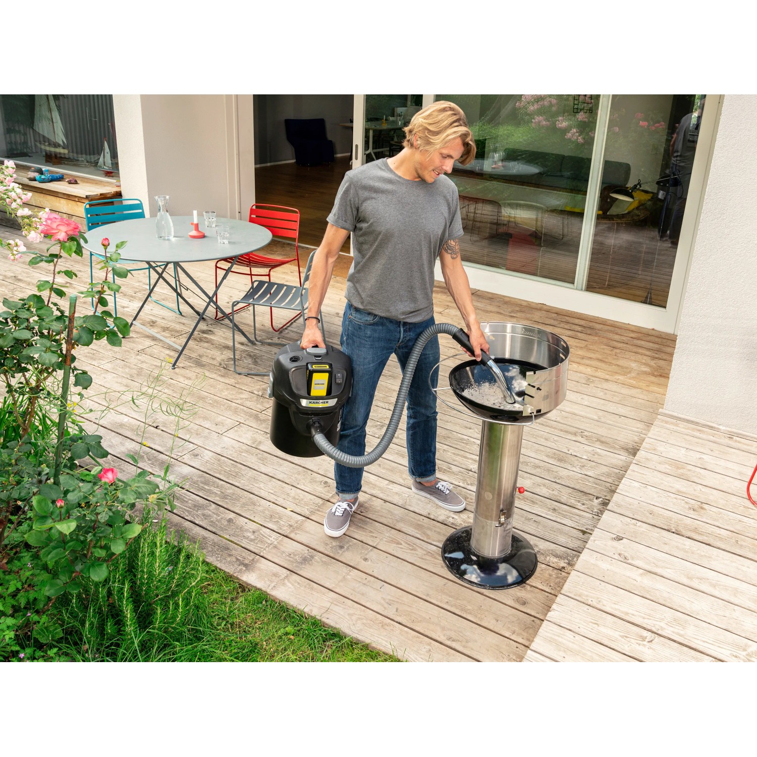 Mann saugt Asche mit dem Kärcher Akku-Aschesauger AD 2 Battery Set vom Grill.