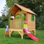 Axi Tom Spielhaus aus Holz mit roter Rutsche und zwei Kindern im Garten.