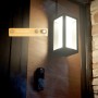 Schwarze Philips Hue Türklingelkamera Secure mit Außenleuchte an einer Holzwand.