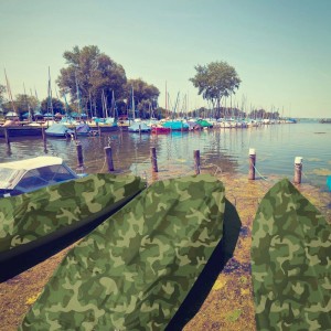 Boote abgedeckt mit KARAT Abdeckplane, wasserdicht, Camouflage, 2x3m, am See.