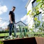 Mann bewässert Garten mit Metabo Akku-Tauchpumpe. Elektro-Pumpe im Einsatz.