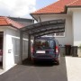 Schwarzer Ximax Alu Carport Portoforte Typ 110 XL mit Auto vor Haus.