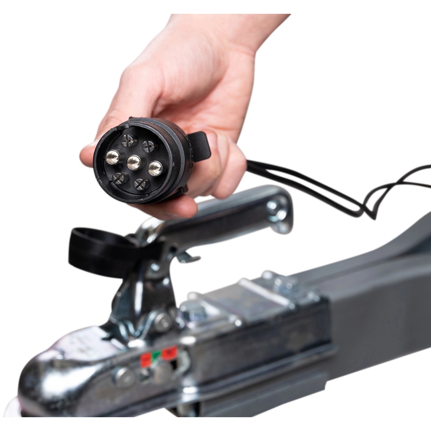 Hand hält 7-poligen Stecker für Stema Anhänger am Zugkopf.
