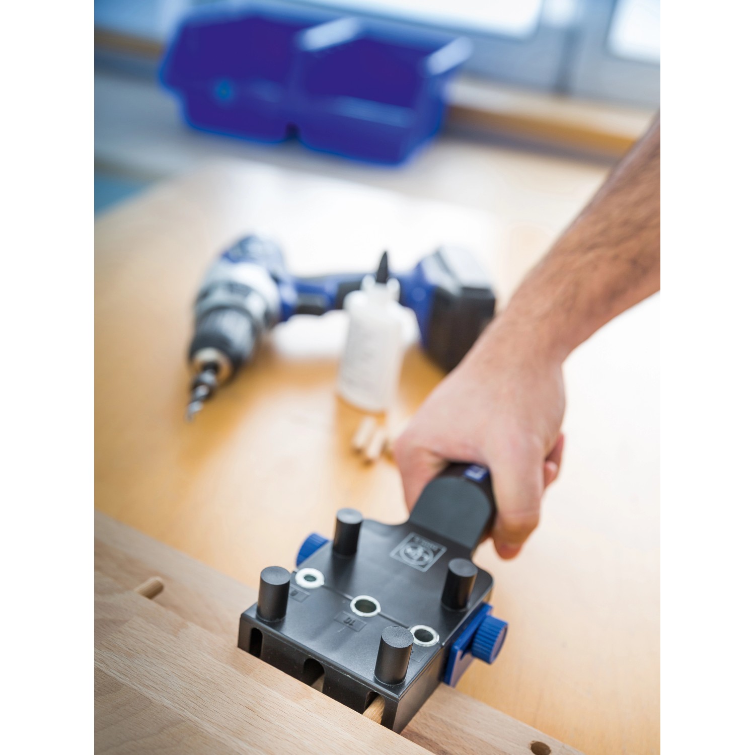 LUX Dübellehre Classic aus Kunststoff in Anwendung auf Holz, Bohrmaschine im Hintergrund.