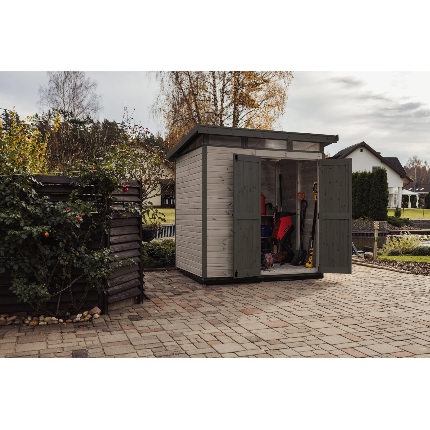 Graues Upyard Gartenhaus Strongbox L mit geöffneten Doppeltüren und Fundament.