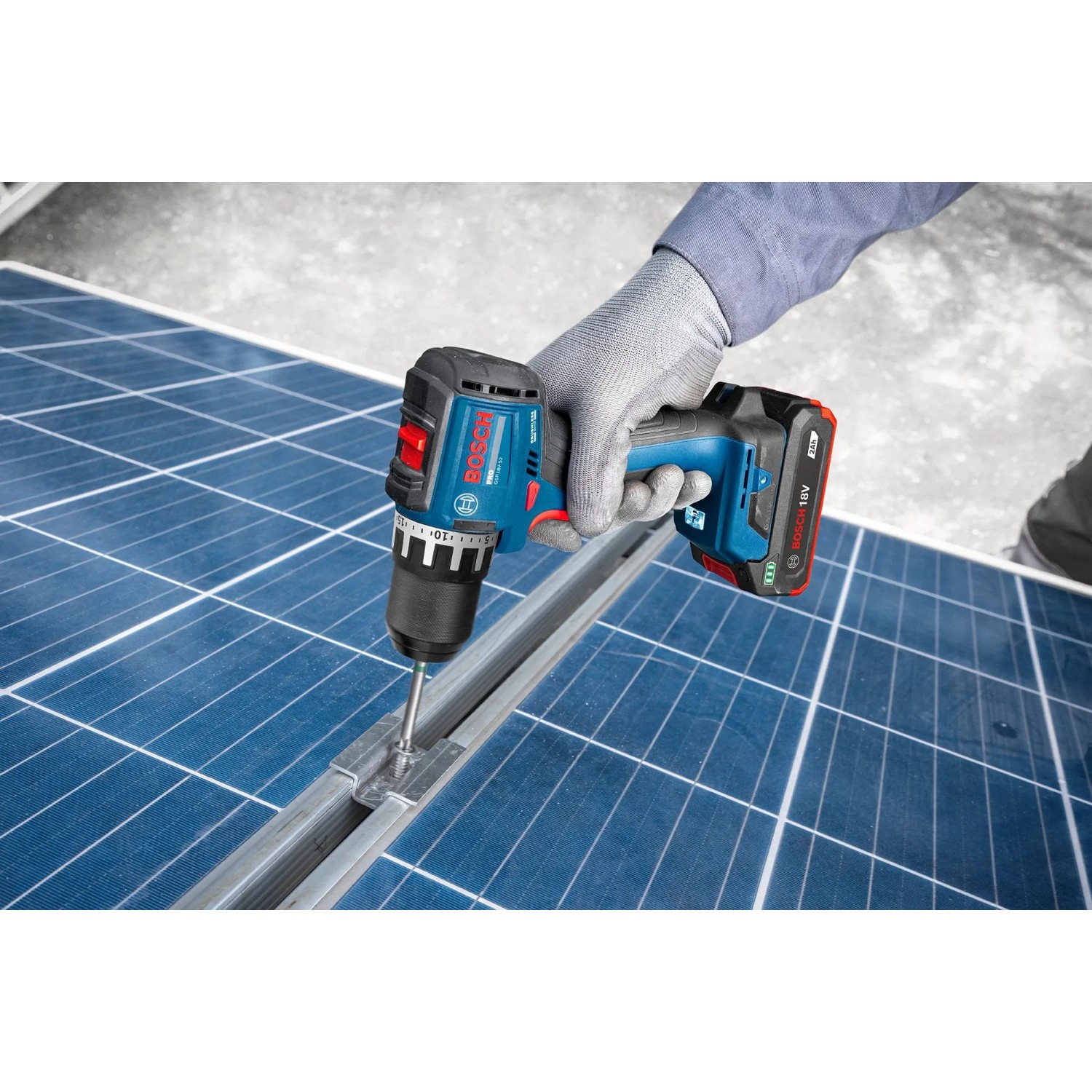 Bosch Professional Akku-Bohrschrauber GSR18V-52 in Blau/Schwarz schraubt in Metallschiene auf Solarpanel. Kompaktes Akkugerät.
