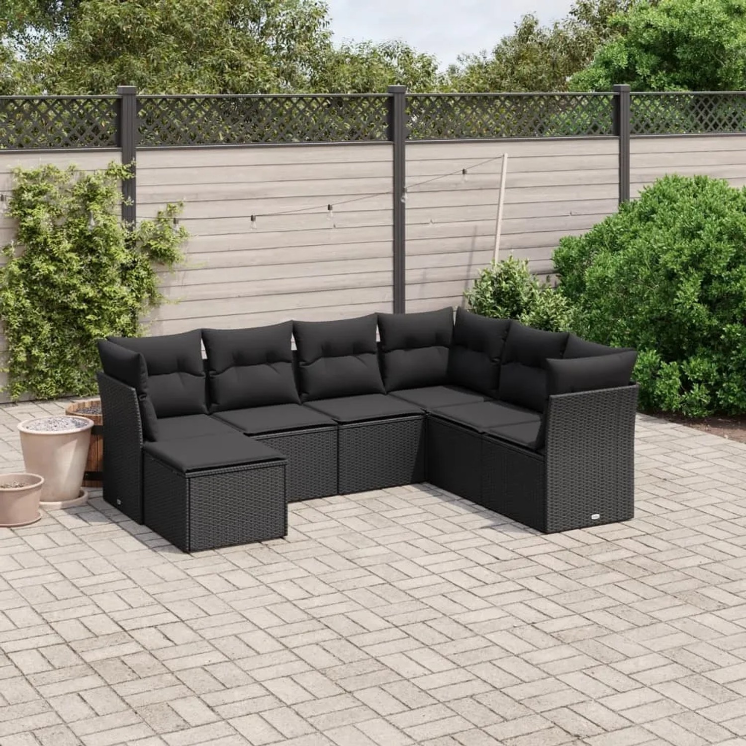 Schwarze 7-tlg. vidaXL Garten-Sofagarnitur aus Poly Rattan mit Kissen im Garten.