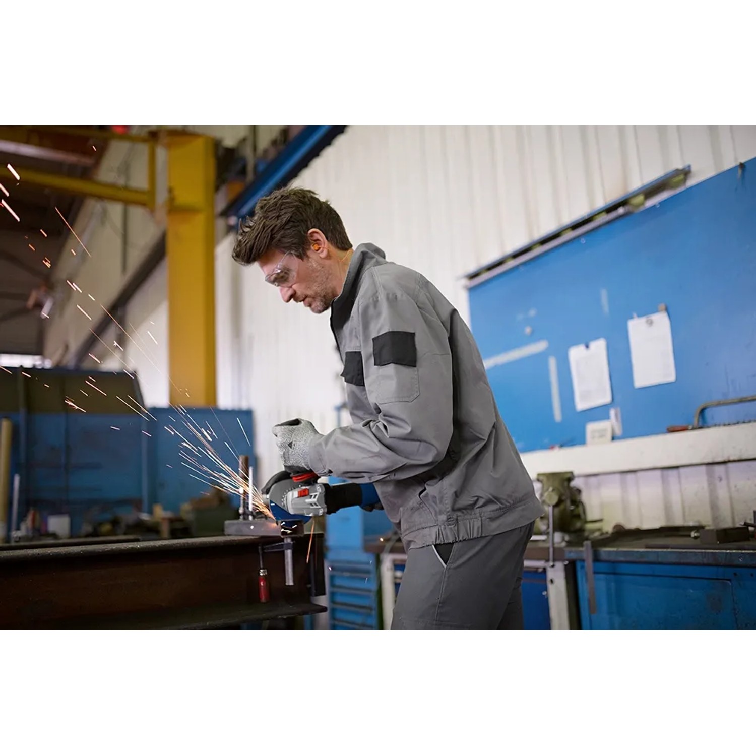 Mann schleift Metall mit Bosch Professional Winkelschleifer GWS 17-125, Funken sprühen.