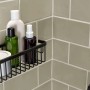 Schwarzer, matter Tesa Aluxx Duschkorb mit Duschutensilien an grauer Wand.