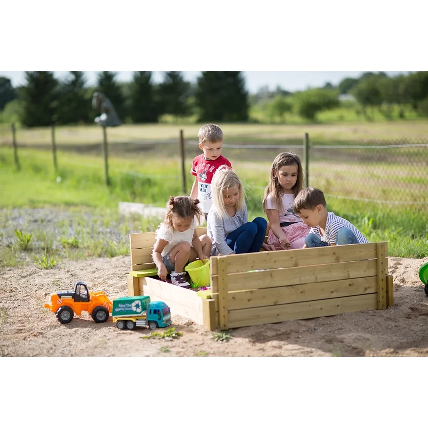 Wendi Toys Sandkasten mit Holzabdeckung und Sitzflächen, bespielt von Kindern im Garten.