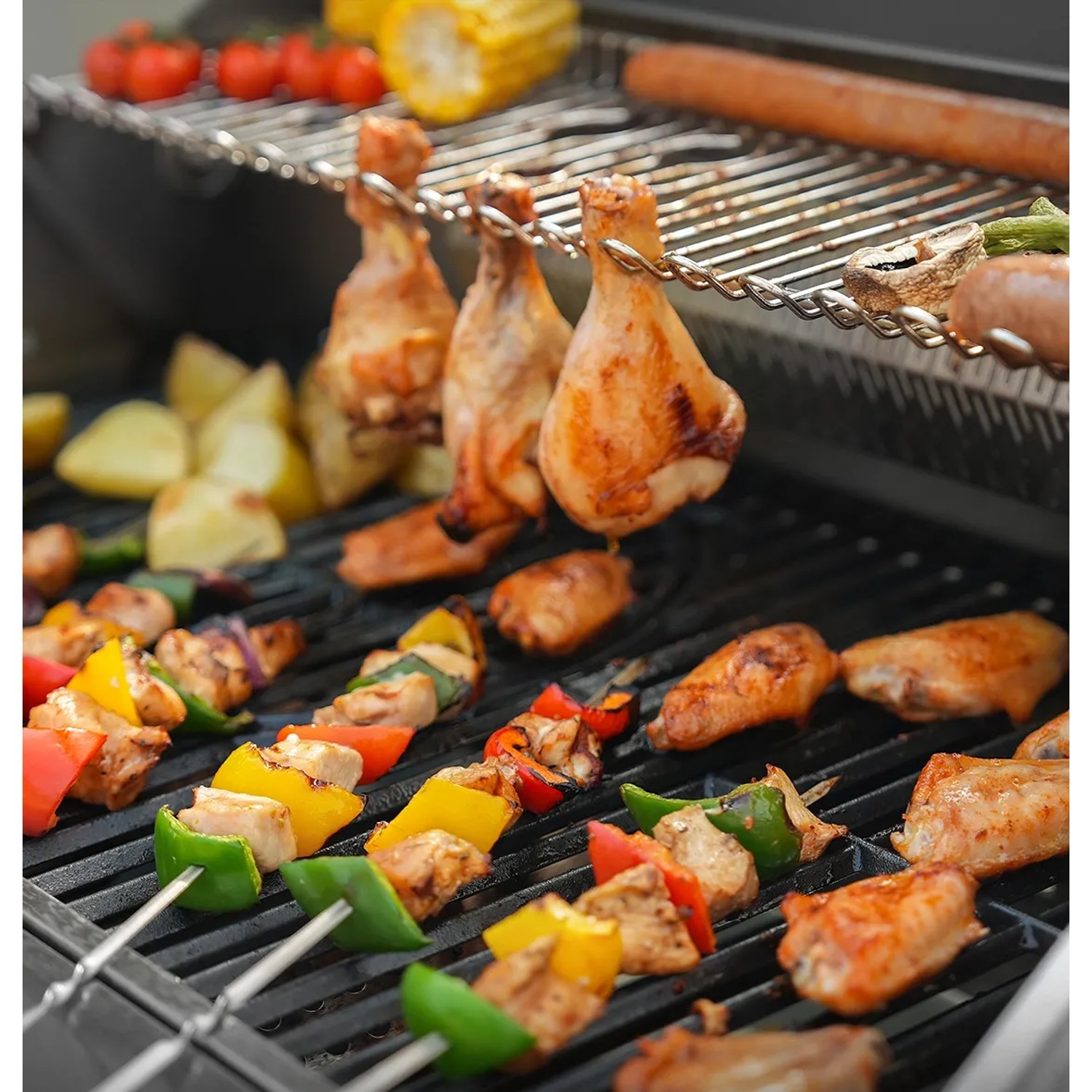 Taino Platinum Yamara Gasgrill mit Hähnchen, Würstchen und Gemüse-Fleischspießen auf dem Grillrost.
