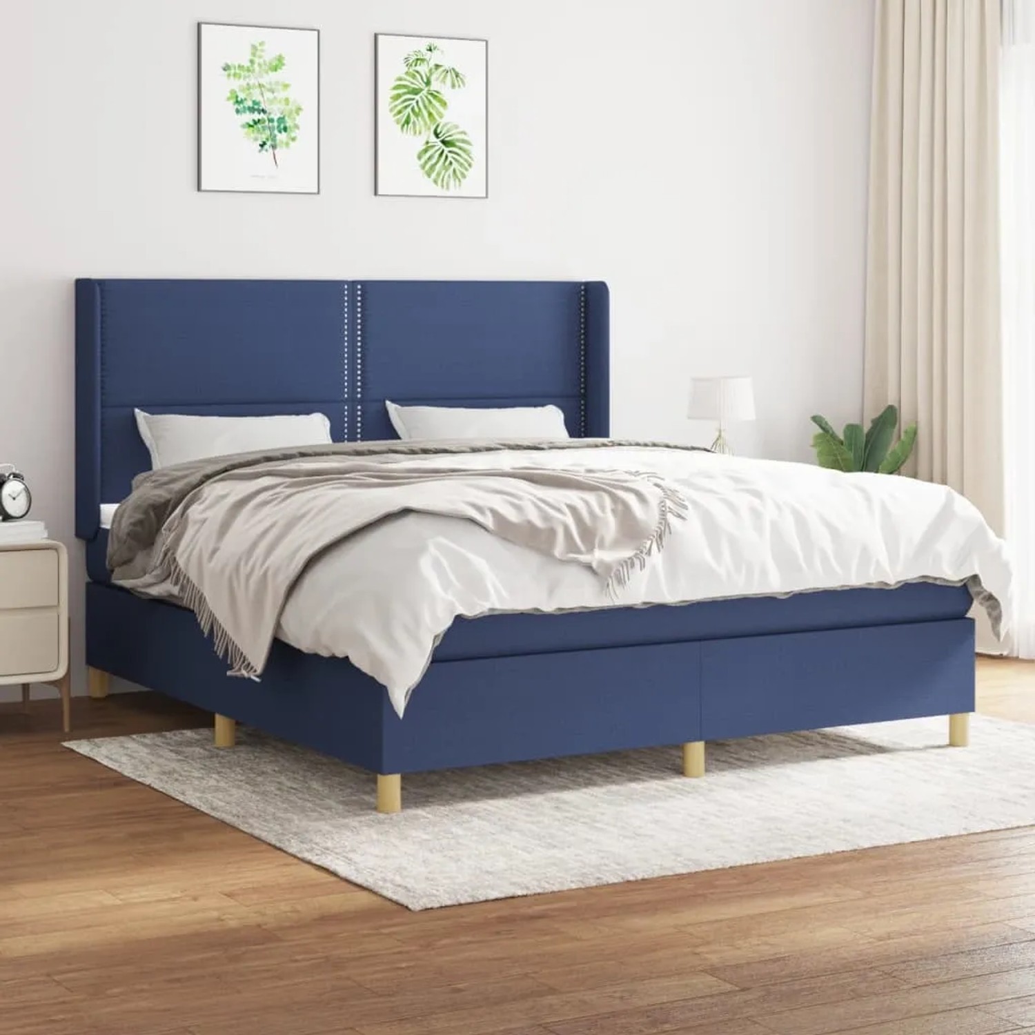 Blaues Boxspringbett (180x200 cm) mit Matratze und Kopfteil im Schlafzimmer.
