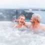 Entspanntes Paar im MSpa Lite Glow AirJet Whirlpool mit Hydromassage im Freien.