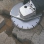 Diamant-Trennscheibe 115 mm im Einsatz mit Winkelschleifer zum Schneiden von Pflastersteinen.