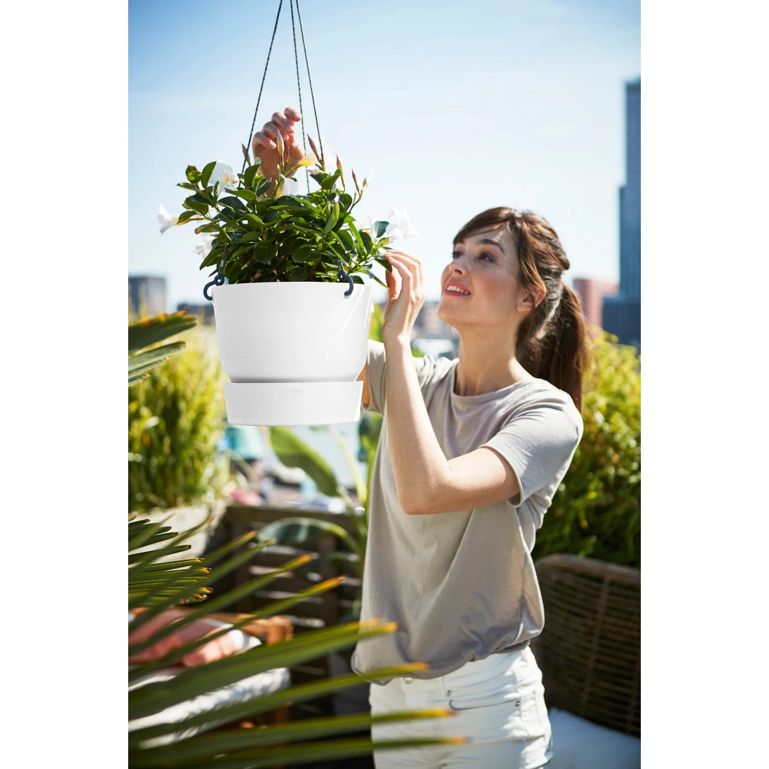 Weiße Elho Hängeampel Greenville (Ø 24 cm) mit Pflanze, aufgehängt auf Balkon.