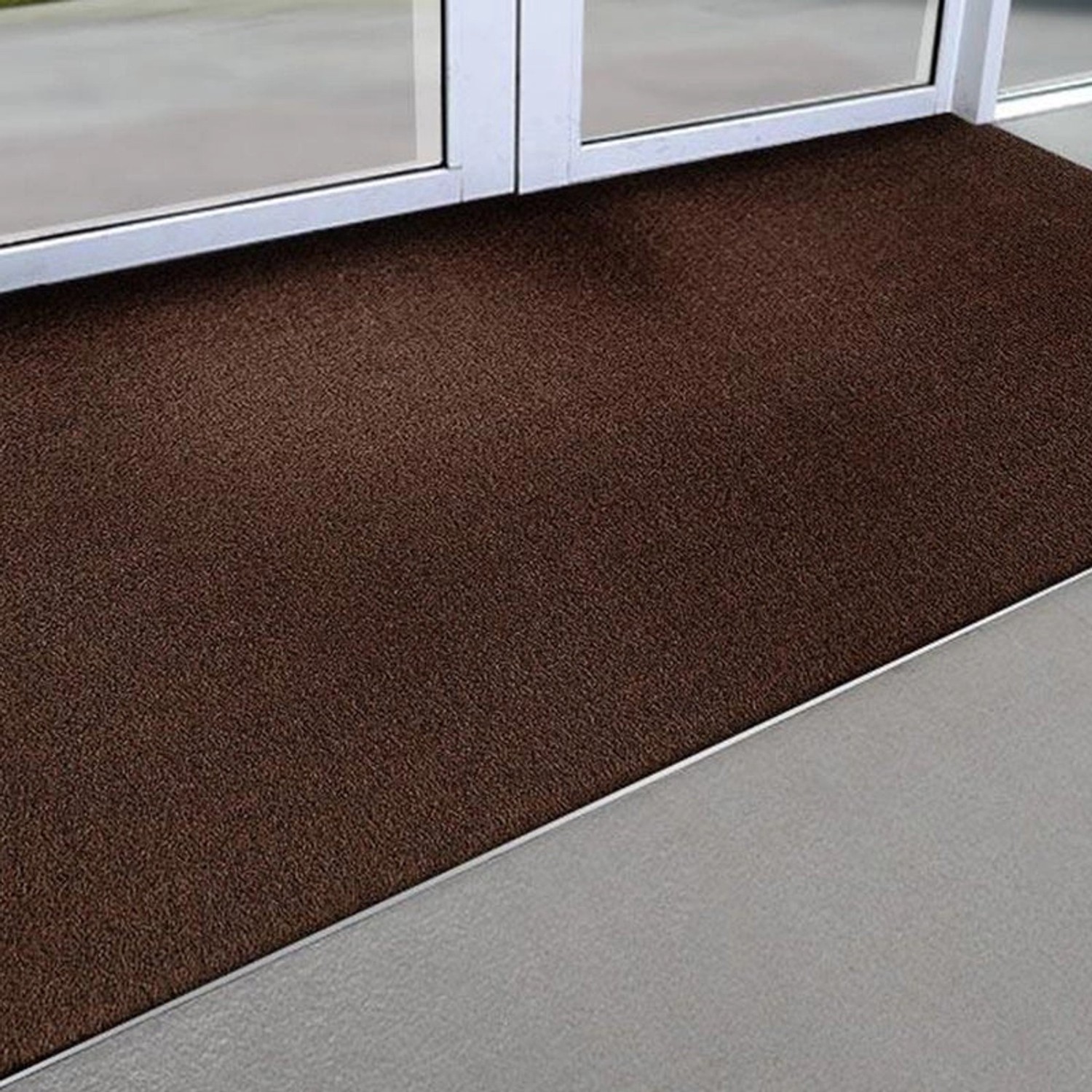 Braune KARAT Kokosmatte als Fußabtreter vor einer Tür, 80x100 cm.