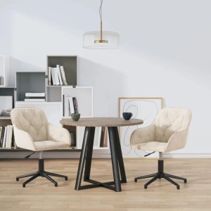 Zwei cremefarbene, drehbare Esszimmerstühle aus Samt an einem runden Holztisch in modernem Ambiente.
