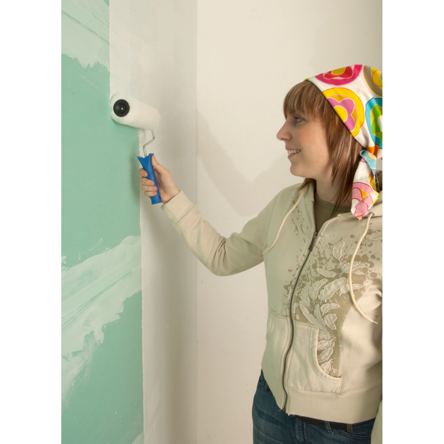 Frau streicht Wand mit Knauf Sperrgrund, 5 kg Eimer für Isoliergrundierung.