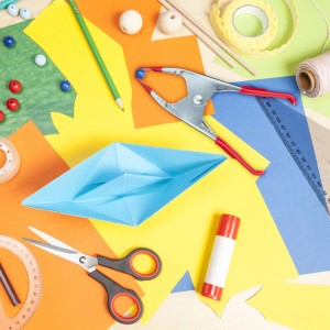 Rote Metall-Klemmzwinge mit rutschfesten Griffen, hält blaue Perle. Ideal für Bastel- & Handwerksarbeiten.