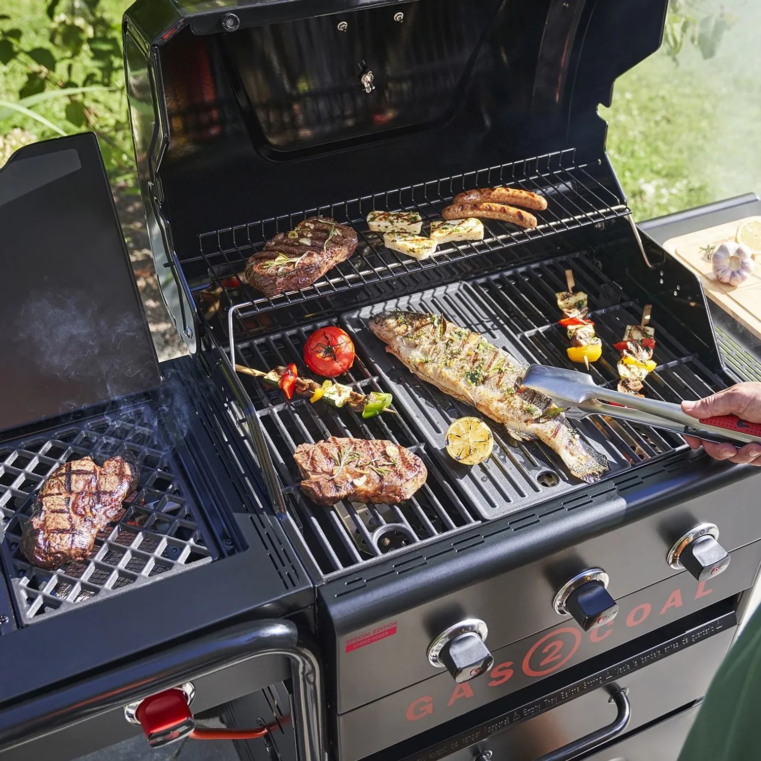 Char-Broil Gas2Coal Hybridgrill Special Edition mit Grillgut wie Steak, Fisch und Gemüse.
