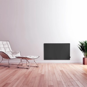 Schwarze Vasner Hybrid-Infrarotheizung Konvi 1200W an Wand im Wohnraum.