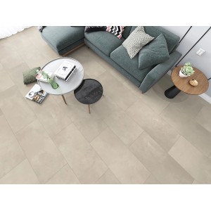 Verlegtes ECO4ALL Pro Bella Grigia Vinyl, Steinoptik, im Wohnraum mit Sofa und Tischen.