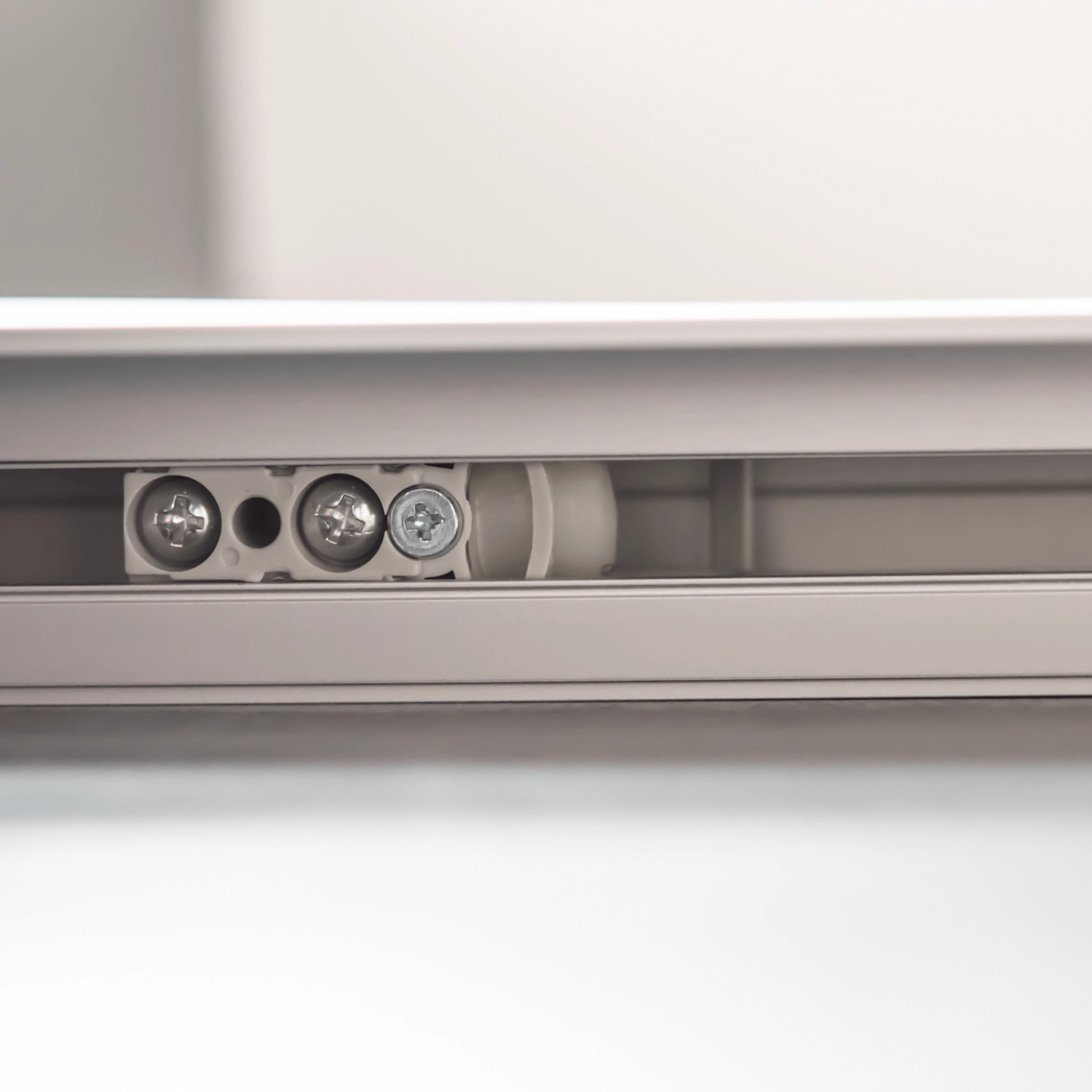 Detailaufnahme der Laufschiene mit Laufwagen der inova Glasschiebetür. Softclose Funktion.