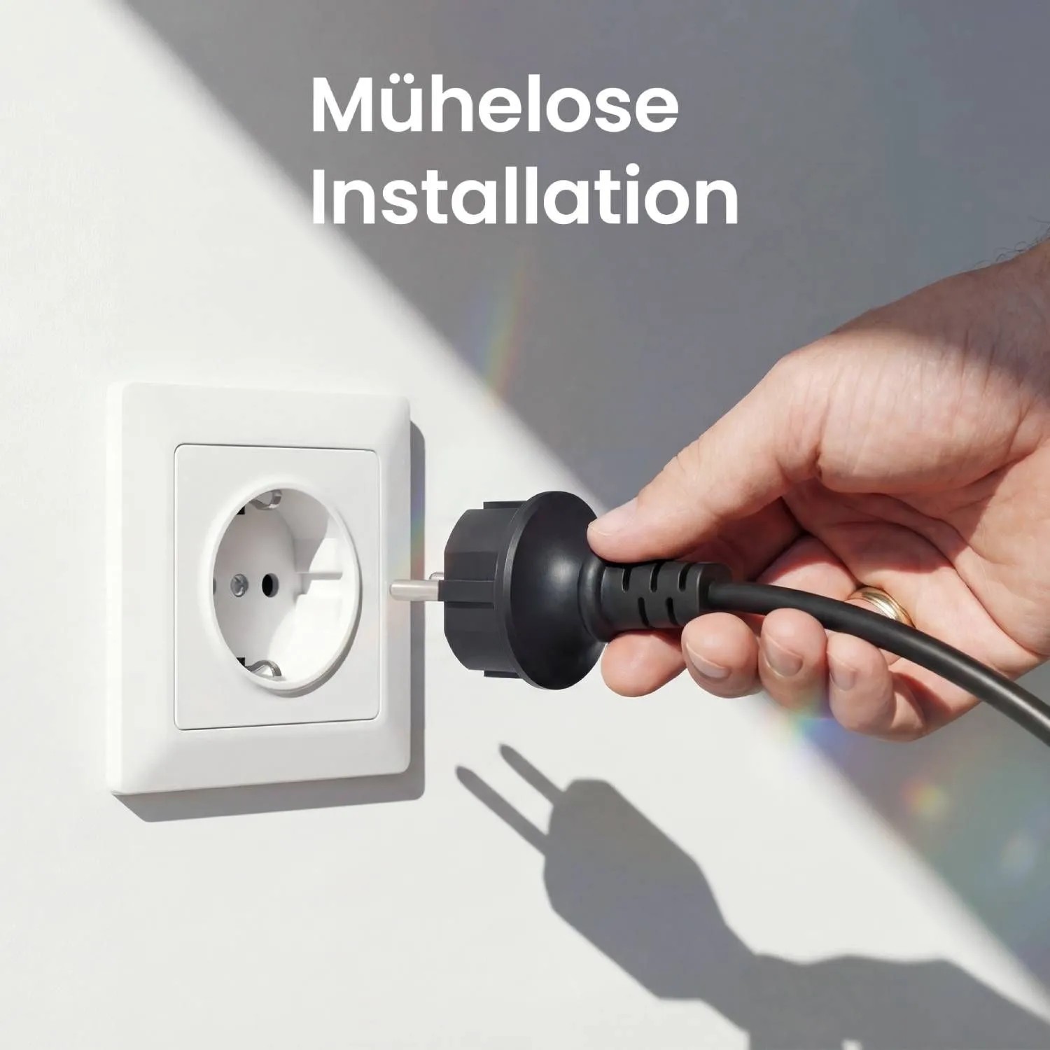 Hand steckt schwarzen Stecker in weiße Steckdose. Einfache Installation des Anker SOLIX Balkonkraftwerks.