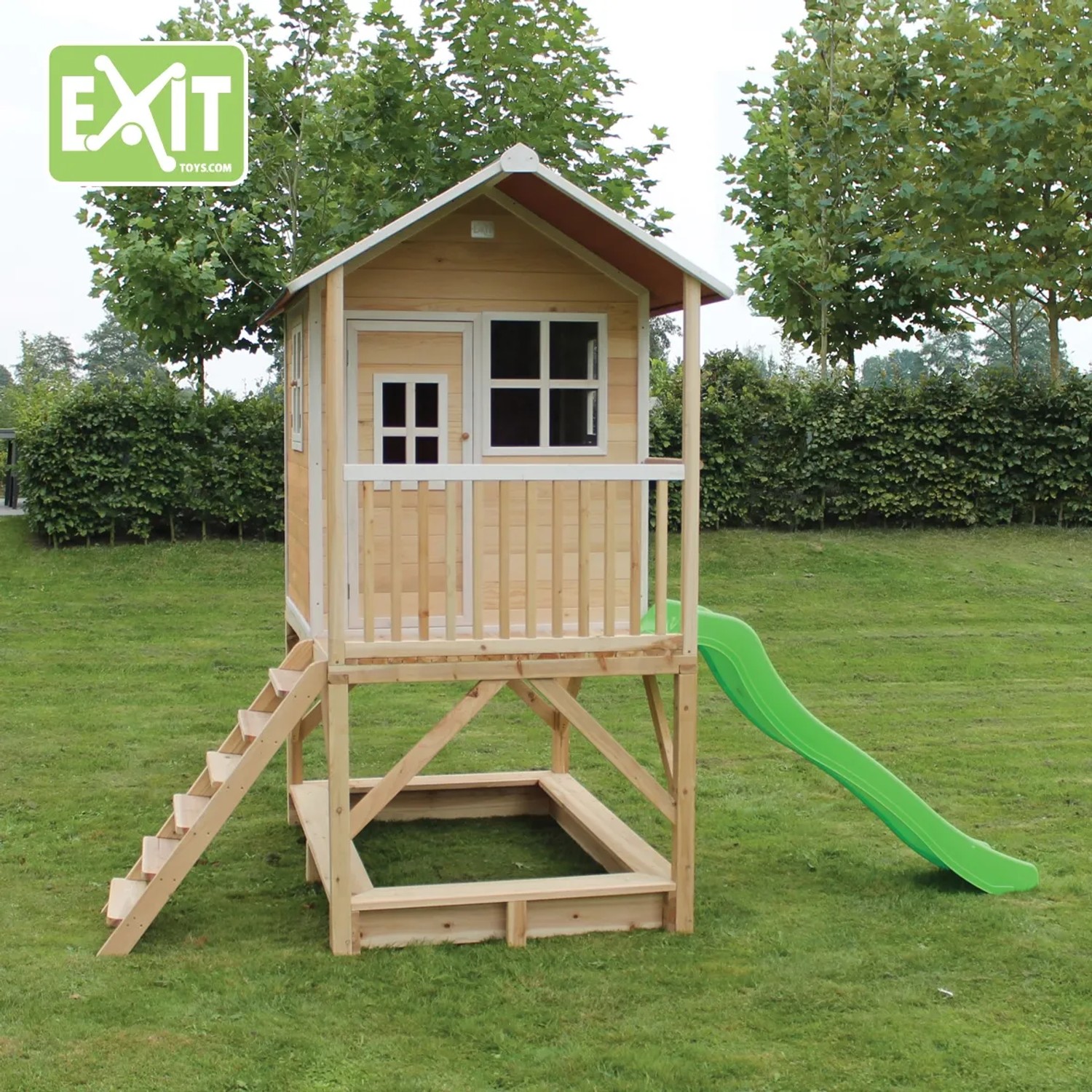 EXIT Loft 500 Holzspielhaus naturel mit Rutsche, Sandkasten und Treppe im Garten.