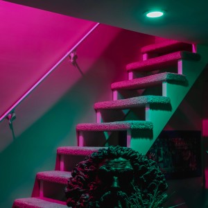 Ledvance Smart+ Reflektor RGBW GU10 Leuchtmittel beleuchtet Treppe in Pink und Grün.