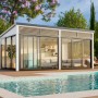 Weißes Palmako Holz-Gartenhaus mit Pultdach (582x297 cm) neben Pool. Gartenhaus mit Schiebetüren.