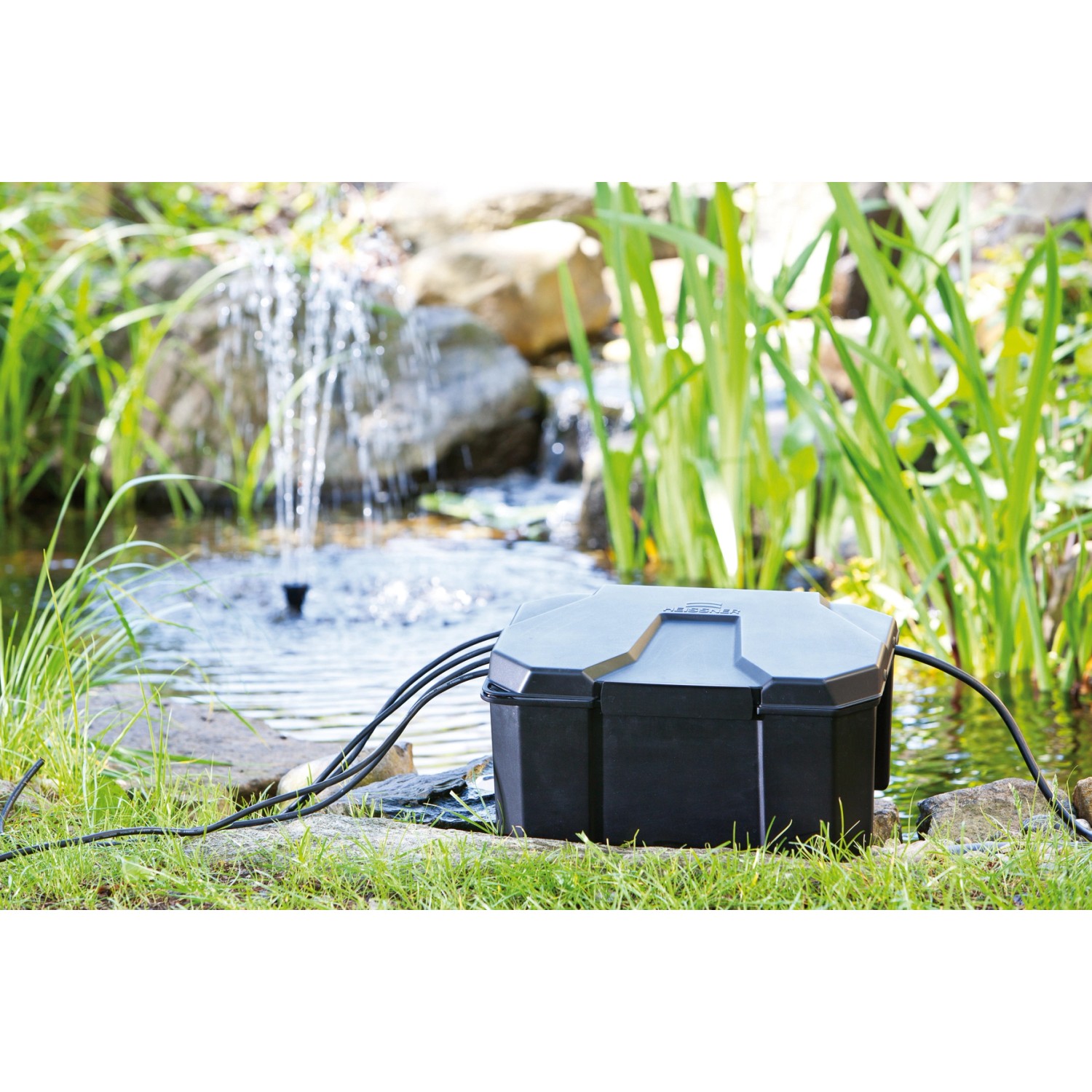 Heissner Garden Power Box im Gartenteich mit Pumpe und Kabeln. Sichere Stromversorgung für Teichpumpen.