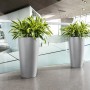 Zwei Lechuza Rondo Premium Pflanzgefäße, Ø 40 cm, 75 cm hoch, in Silber metallic mit grünen Pflanzen.