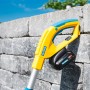 Gloria Finecut 18 V Akku-Trimmer: Rasen- und Kantenschneider mit Akku vor Steinmauer.
