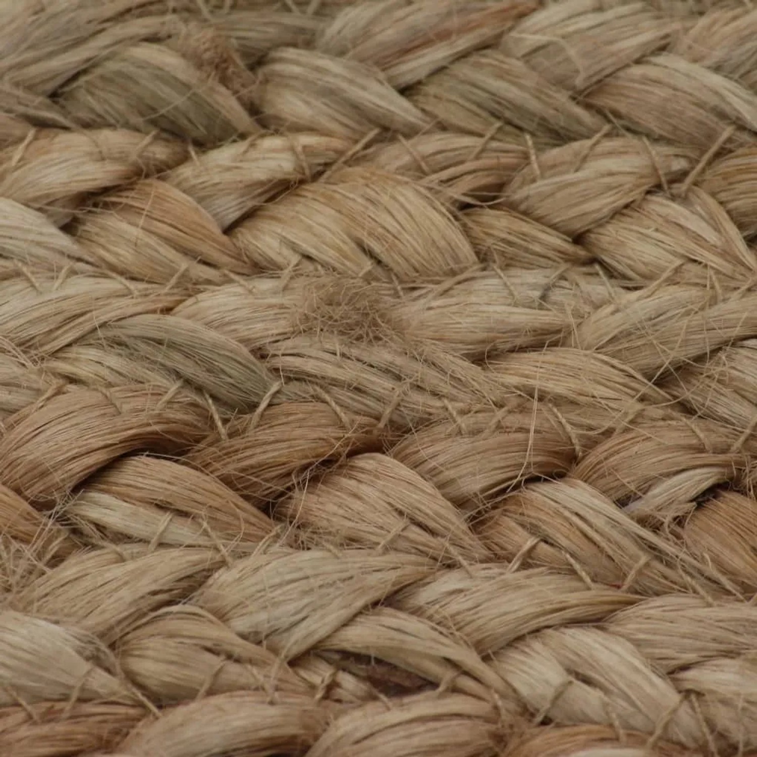 Nahaufnahme der geflochtenen Jute-Textur eines runden Teppichs in Naturtönen. Robust und langlebig.