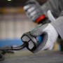 Detailaufnahme: Hand mit Handschuh bedient Bosch Professional Winkelschleifer GWS 17-125.