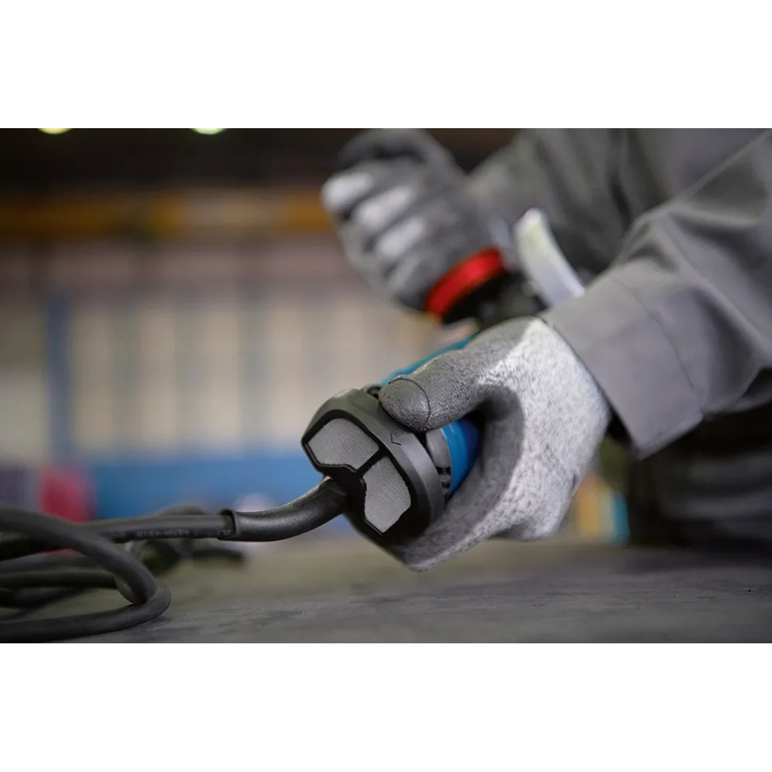 Detailaufnahme: Hand mit Handschuh bedient Bosch Professional Winkelschleifer GWS 17-125.