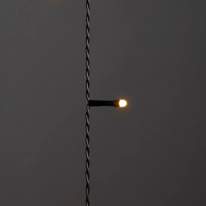 Detailaufnahme: Konstsmide LED-Baummantel mit warmweißer LED an schwarzem Kabel. Außen-Lichterkette.