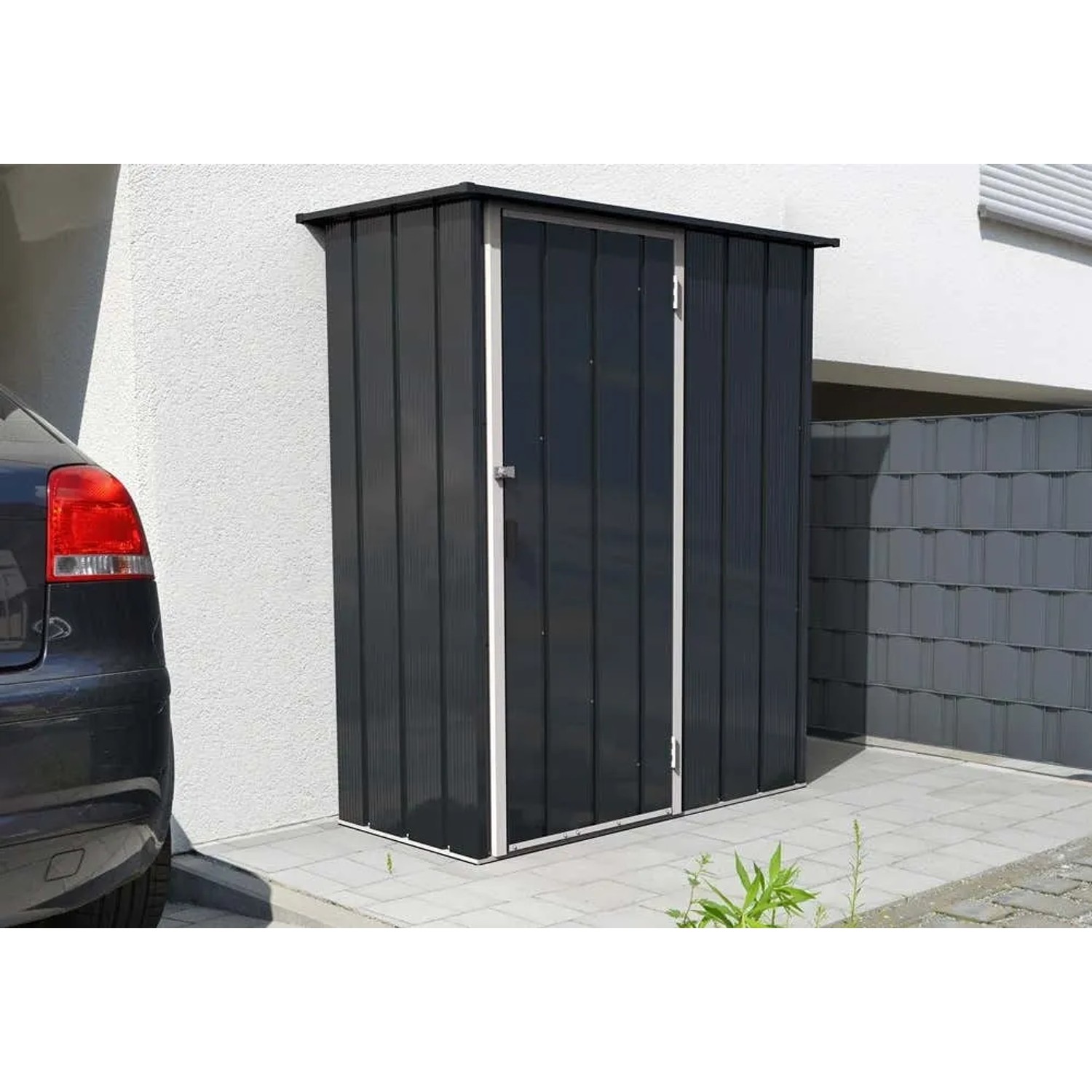 DURAMAX Metall-Gerätehaus Easy 1,5x0,6m in Anthrazit vor Hauswand.
