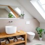Modernes Bad mit Könighaus Infrarotheizung Spiegel, Waschbecken und Toilette unter Dachfenster.