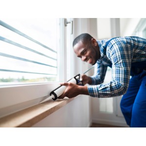 Handwerker dichtet Fenster mit LUX Kartuschenpresse ab.