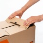 Hände falten OBI Umzugskarton XL (75x42x40cm) zu. Ideal für Umzüge und zum sicheren Transport.