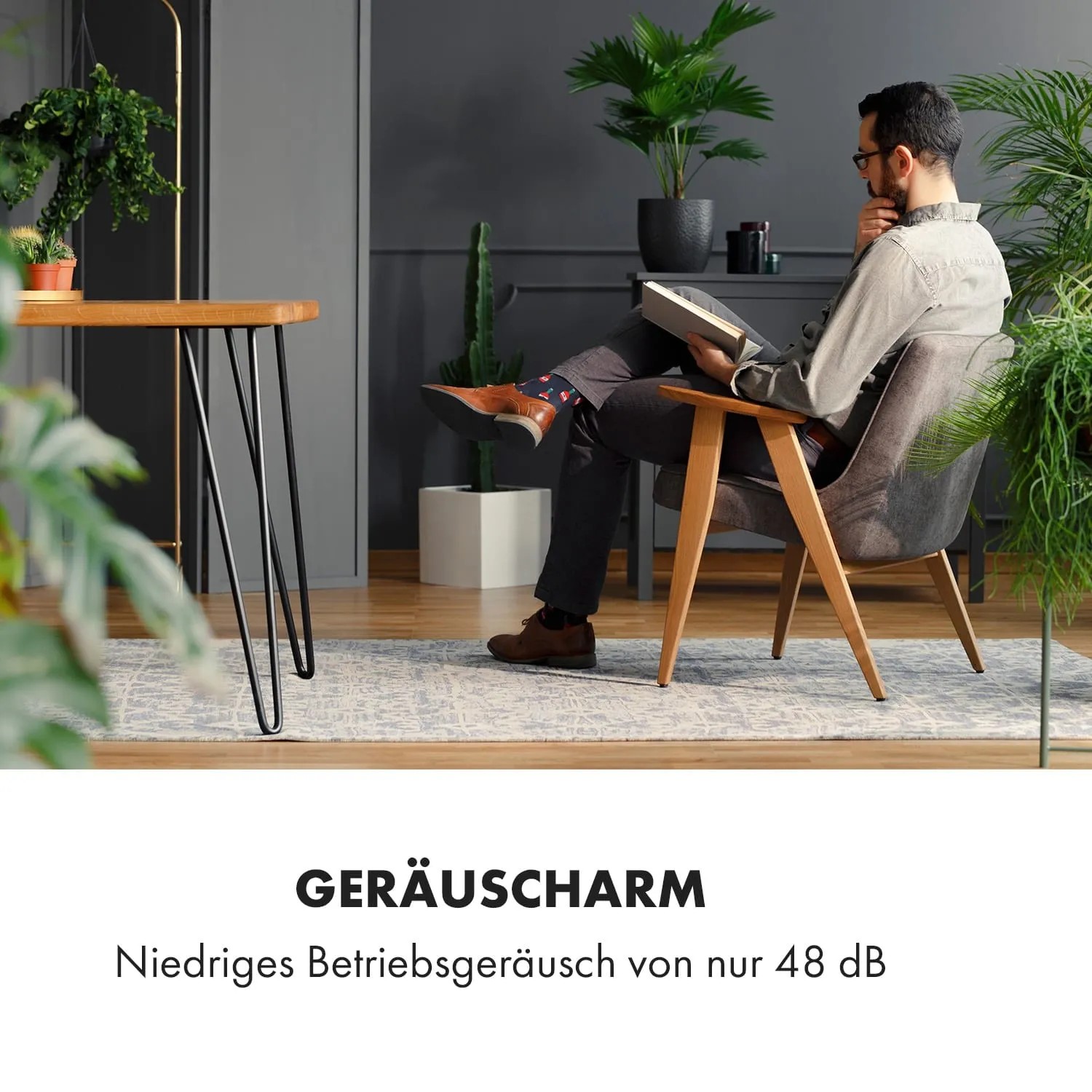 Mann liest entspannt im Sessel, Klarstein Klimaanlage sorgt für Ruhe.