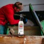 Ballistol Harzlöser Pumpspray 150 ml auf Holzbalken, im Hintergrund ein Handwerker an einer Säge. Entfernt Harz von Werkzeugen.