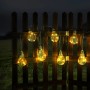 Globo LED-Solarlichterkette in Silber-Grau mit 10 warmweißen Glühbirnen am Holzzaun.