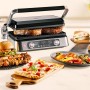 Braun Multigrill 9 Pro Kontaktgrill in Silber mit Speisen wie Burger, Pizza und Fleisch.