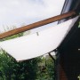 Floracord Vierecksonnensegel in Elfenbein, 330x200 cm, montiert an einer Hauswand.