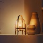 Philips Hue E14 Kerzenform Leuchtmittel leuchtet warmweiß in einer dekorativen Laterne auf einem Regal. Smartes Licht für Zuhause.