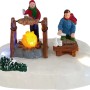 Weihnachtsdorf Grill Camping Szene: Zwei Figuren bereiten Fisch am leuchtenden Lagerfeuer auf Schnee zu. Weihnachtsdekoration.